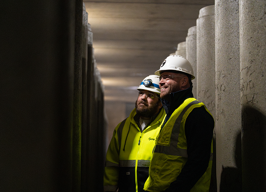 County Materials supervisors inspecting concrete products in a manufacturing facility, representing management and leadership roles.