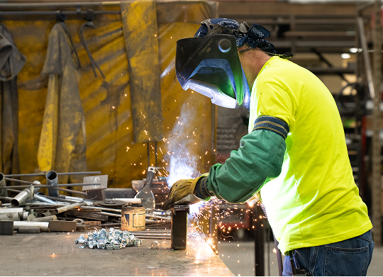 County Materials team member welding metal components in a production facility, representing technical and hands-on career experience.