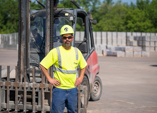 County Materials team member standing beside a forklift in a production yard, representing service members and veterans in the workforce.